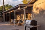 Covered patio with outdoor dining and BBQ grill